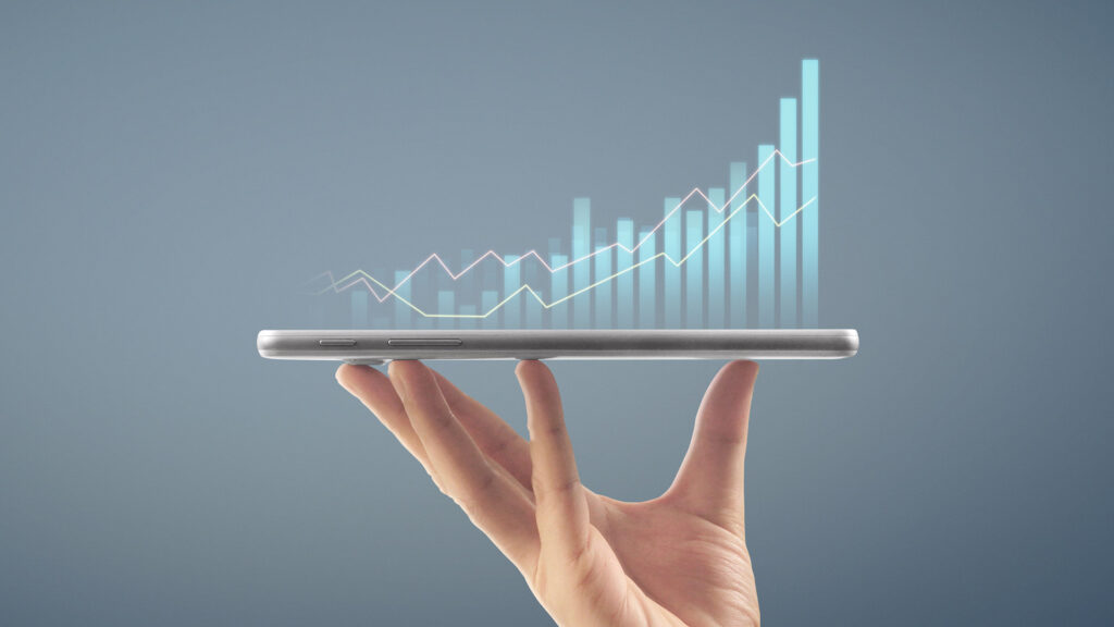 Person holding mobile with chart graphics coming out of it
