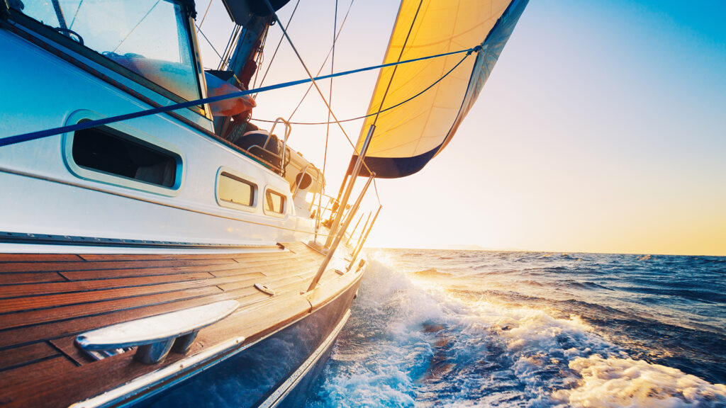 Boat sailing into the sunset at sea