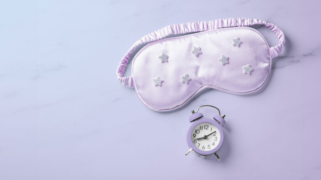 Purple sleeping eye mask with little alarm clock