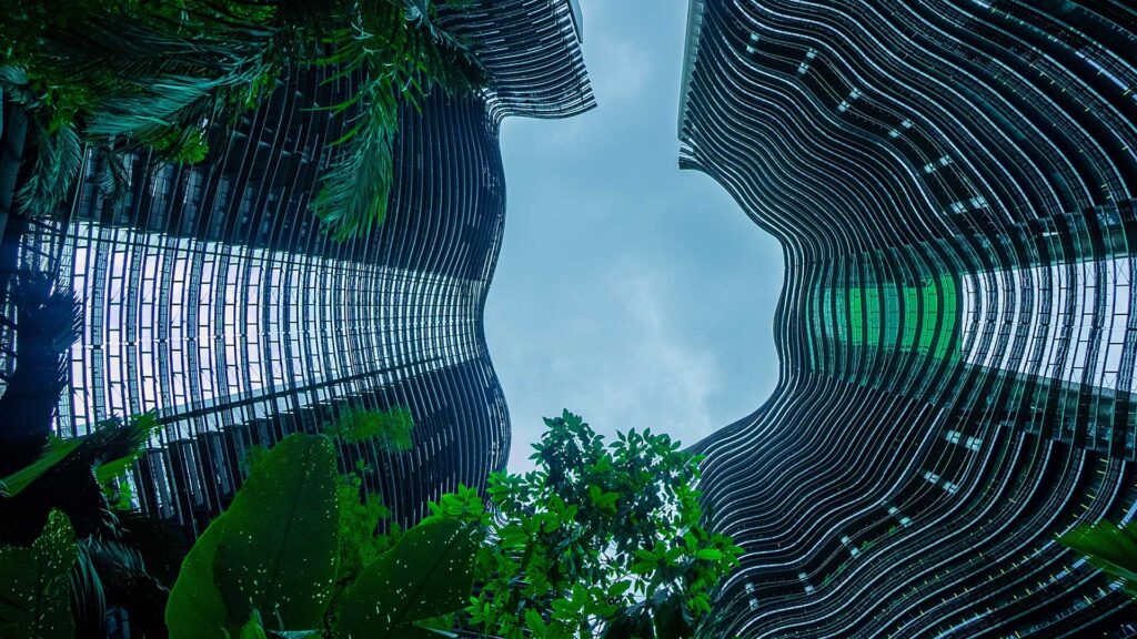 View up buildings from ground level with green trees