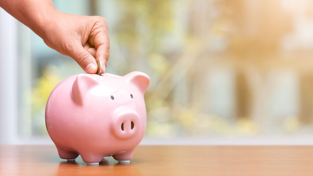 Person putting money in piggy bank