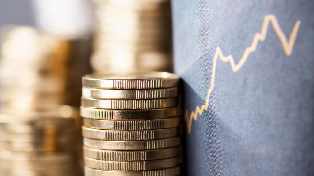 Stacks of coins next to an upward graph