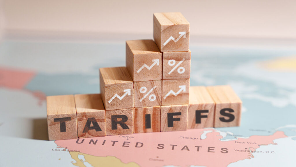 Wooden blocks spelling tariffs placed on top of United States on a map