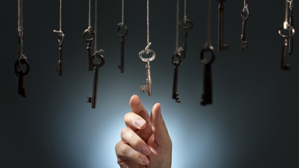 Person picking the right key out of a bunch of hanging keys